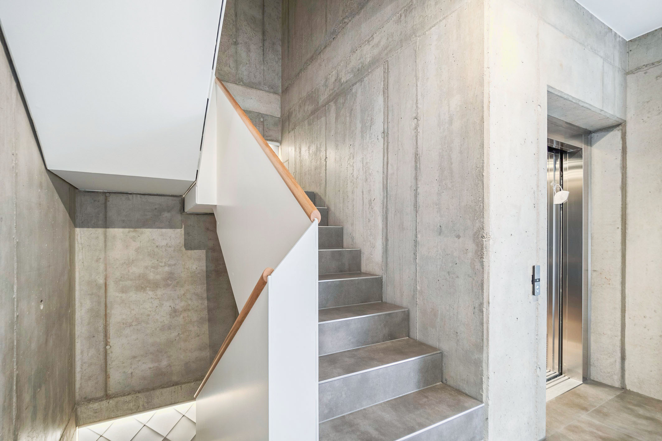 Modernes Wohn und Gewerbegebäude mit Sichtbeton Holz und Aluminium mit barrierefreiem Aufzug